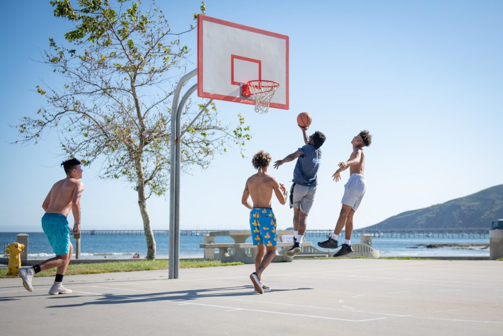 estudiantes jugando a basquet en frente de la playa